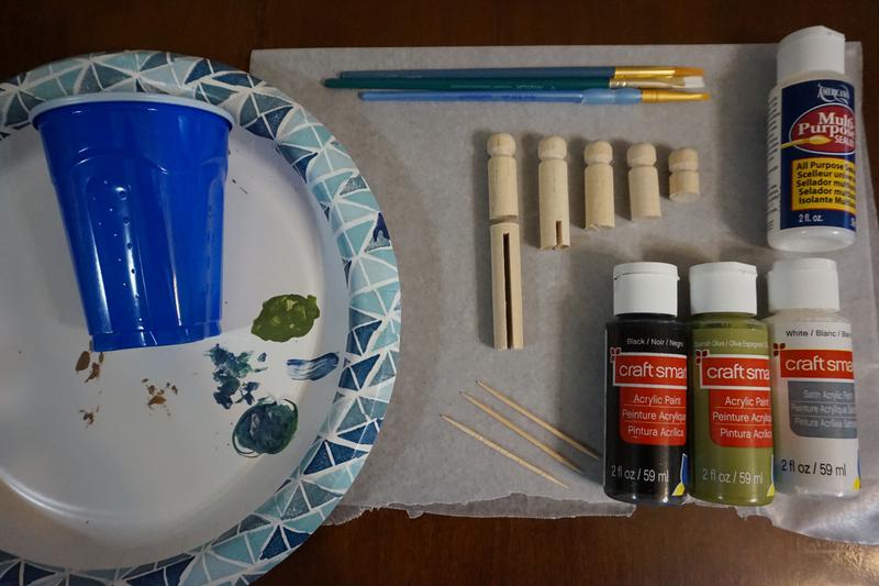 plastic cup, paper plate, brushes, clothespins, toothpicks, paint, and sealant